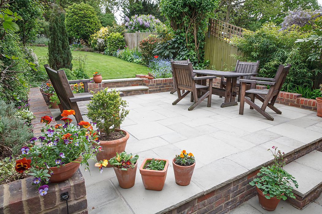 Hardscaped patio area with multiple potted plants